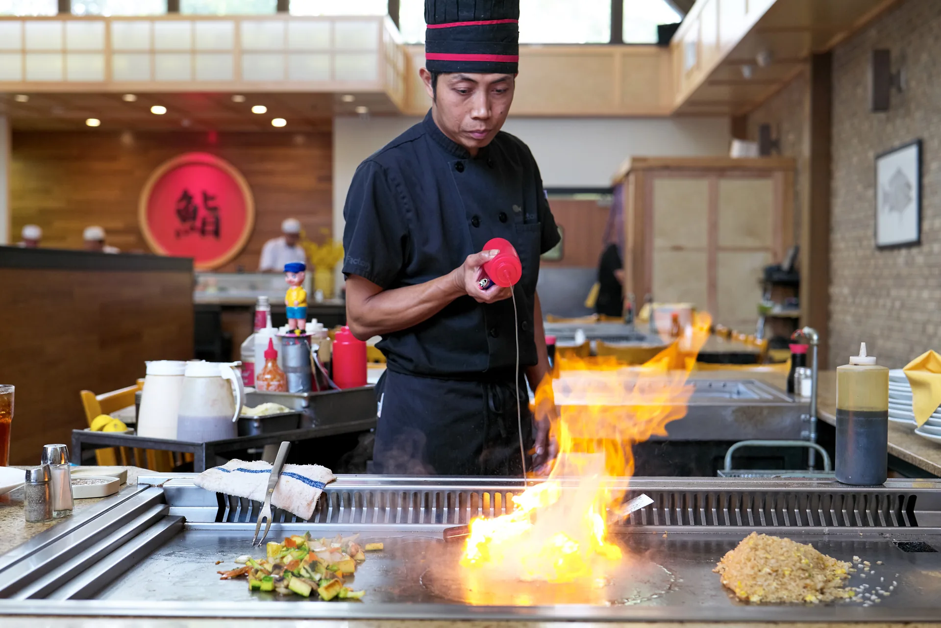 Hibachi chef grilling with flames at Sake Café Pensacola